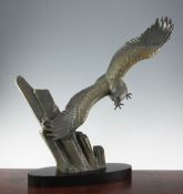 A French Art Deco patinated metal model of an eagle in flight, with oval black marble base, marked