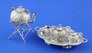 An early 20th century Chinese silver miniature four piece tea set including tongs, a similar two