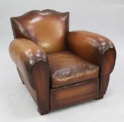 A 1930's brown leather upholstered armchair, with shaped back and rounded arms