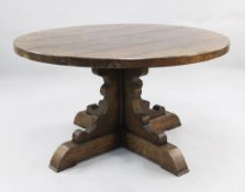 A large circular oak dining table, on cruciform base, W.4ft 6in.