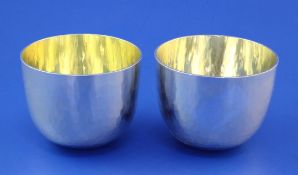 A matched pair of modern silver tumblers by Paula Mary Frances Tollhurst, of planished circular