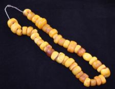 A single strand graduated amber bead necklace, most beads of compressed disc form, with chain