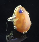 A gold, amber and sapphire set dress ring, the pear shape amber with inset round cut sapphire,