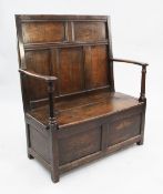 An 18th century open arm settle, with panelled back and box seat with hinged lid, W.3ft 4in.