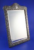 A late Victorian silver mounted easel mirror, of rectangular form, with domed top and decorated with