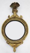 A large Regency circular gilt convex wall mirror, the acanthus crest with eagle mount, the inner