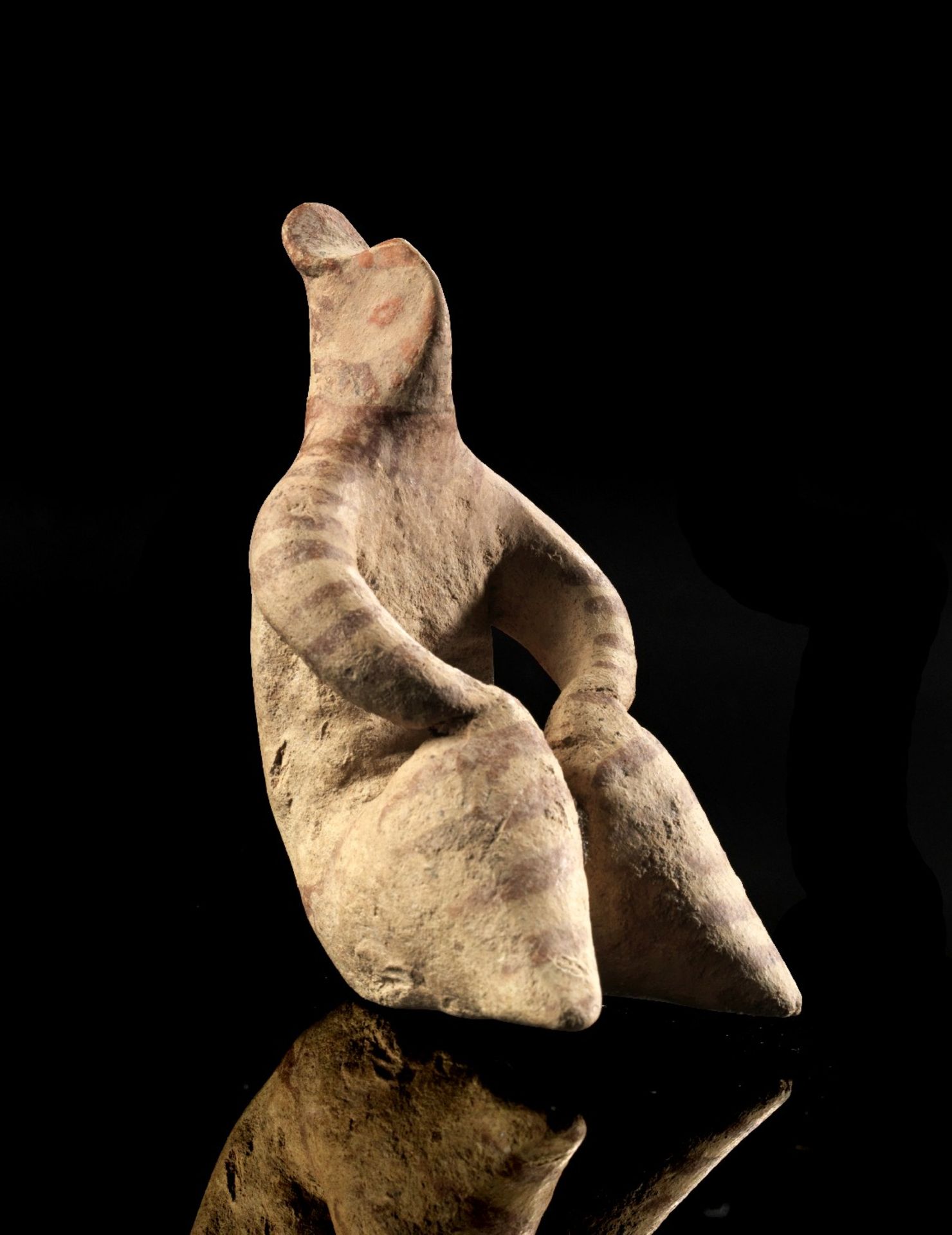 Tonidol des Tell-Halaf-Typus. Nordmesopotamien, 5. Jt. v. Chr. H 8,2cm. Sitzende, weibliche Figur