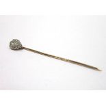 A DIAMOND CLUSTER STICKPIN the central pendeloque cut stone of approximately 0.2cts, enclosed by ten