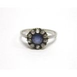 A SAPPHIRE AND ROSE DIAMOND CLUSTER RING the circular cut stone of approximately 5.2mm diameter,