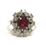 A RUBY AND DIAMOND 18CT GOLD CLUSTER RING the oval cut ruby, measuring 6.7mm by 5.1mm by 2.8mm deep,