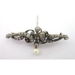 A LATE VICTORIAN DIAMOND AND PEARL BROOCH of long asymmetrical scroll design, set with thirty six