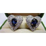 A PAIR OF DIAMOND AND SAPPHIRE HEART SHAPED CLUSTER EARSTUDS apparently unmarked, the inverted