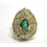 AN EMERALD AND DIAMOND 18CT GOLD CLUSTER RING  the pendeloque emerald to a ballerina mount of twenty