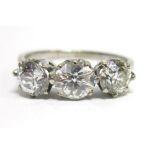 A THREE STONE DIAMOND RING the white mount stamped 18ct, the graduated old brilliant cuts