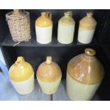 A GROUP OF STONEWARE FLAGONS to include a five gallon straight sided example 53cm high; two two-