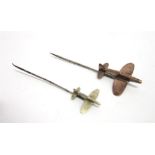 A COPPER FIGHTER PLANE STICKPIN with another smaller white metal example Note: The vendor's mother