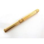 A VICTORIAN GILT METAL PROPELLING DIP PEN/PENCIL of octafoil outline with engine turned