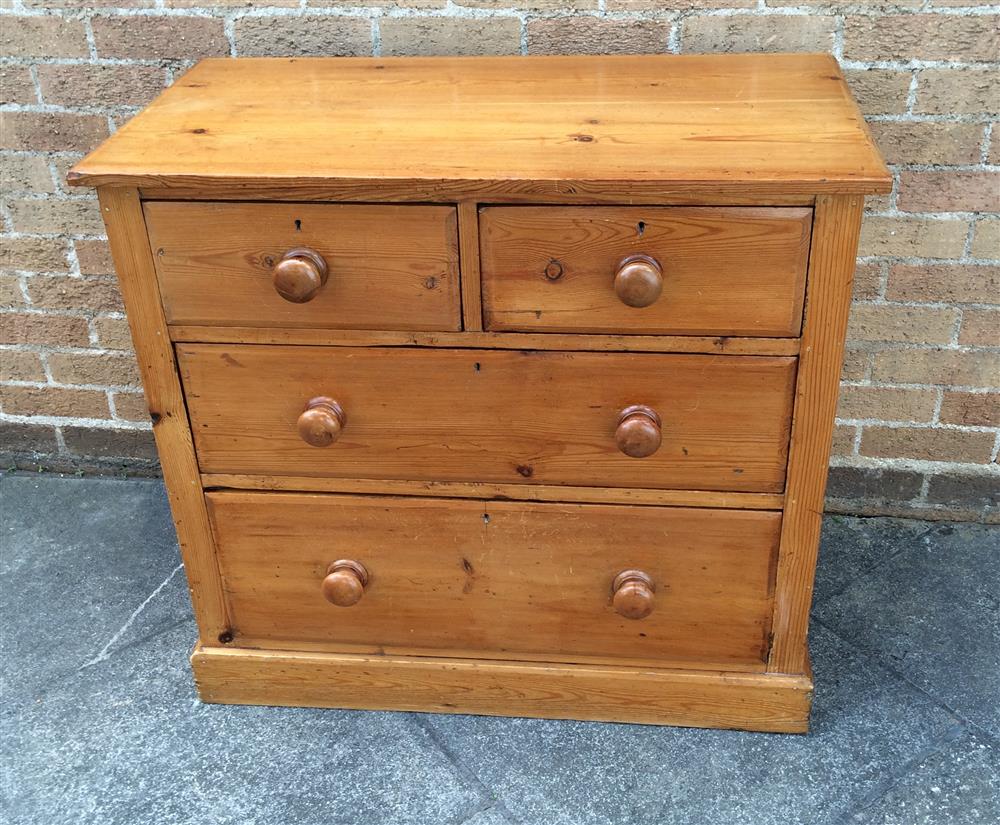 A PINE CHEST  of two short and two long graduated drawers with turned wooden handles and on plinth