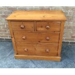 A PINE CHEST  of two short and two long graduated drawers with turned wooden handles and on plinth