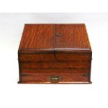 AN EDWARDIAN OAK TABLE TOP STATIONERY BOX the sloping front opening to reveal fitted interior with