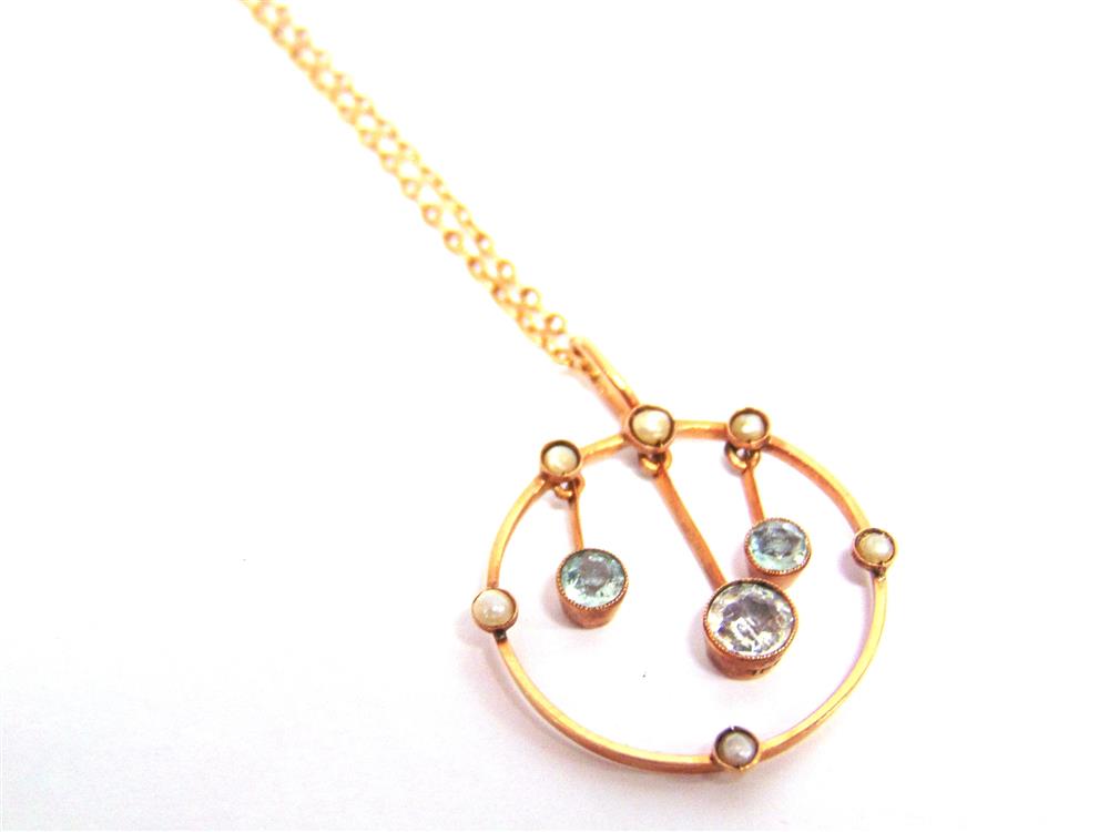 AN EDWARDIAN AQUAMARINE AND SEED PEARL PENDANT  The circular pendant enclosing three drops, seed