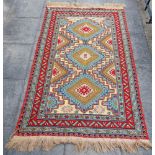 A WOOL RUG centred with three hooked medallions within a bordered design, 232 x 150cm