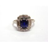 A SAPPHIRE AND DIAMOND PANEL RING the oval cut sapphire with a baguette diamond to either side, with