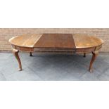 AN EXTENDING OVAL OAK DINING TABLE with inlaid decoration, on cabriole supports with two