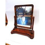 A VICTORIAN FIGURED MAHOGANY TOILET MIRROR 65.5cm high overall, the shaped base 57cm wide 25.5cm