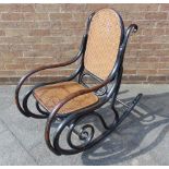 A BENTWOOD ROCKING CHAIR in the manner of Thonet, with caned seat and back panel