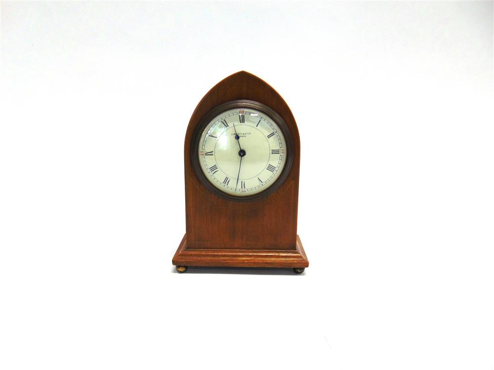 LIBERTY & CO: AN EDWARDIAN MANTLE CLOCK, in lancet shaped mahogany case with line inlaid decoration,