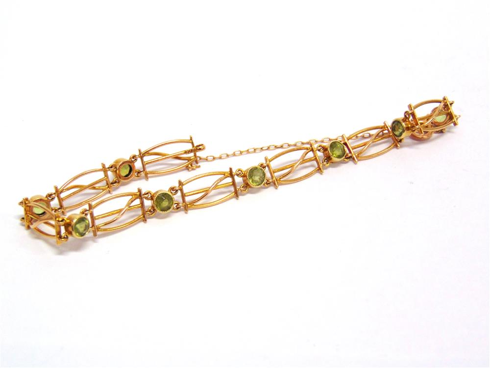 A PERIDOT BRACELET the eight round cut stones with openwork panels between, 8.4g gross