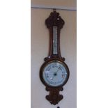AN EDWARDIAN CARVED OAK ANEROID BAROMETER/THERMOMETER, with ceramic dial, 83cm high; together with