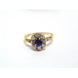 A SAPPHIRE AND DIAMOND CLUSTER RING  the oval cut sapphire approximately 5 x 4.2 x 3mm deep,