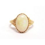 A SINGLE STONE OPAL RING stamped '15', claw set between engraved shoulders, finger size H, 2g gross