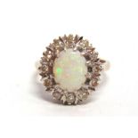 AN OPAL AND DIAMOND 18 CARAT WHITE GOLD CLUSTER RING the oval shallow cabochon approximately 10.9 by