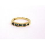 A DIAMOND AND EMERALD 9 CARAT GOLD HALF HOOP RING the five round cut channel set emeralds