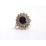 A SAPPHIRE AND DIAMOND 18 CARAT GOLD CLUSTER RING the oval cut sapphire approximately 9 by 7 by 4.