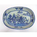 A CHINESE EXPORT OVAL DISH,  with underglaze blue painted decoration depicting buildings in a