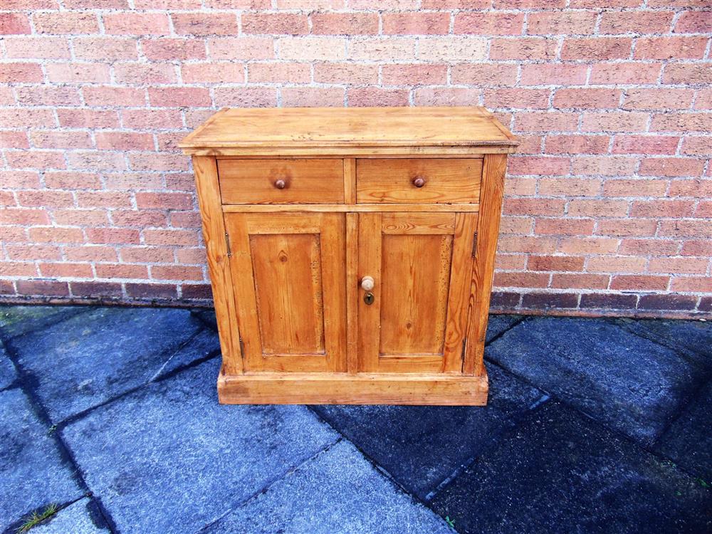 A STRIPPED PINE CUPBOARD,  fitted with two drawers over cupboard, 85cm wide 47cm deep 84cm high