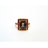 A SMOKEY QUARTZ AND RUBY DRESS RING stamped '750', the millennium cut stone enclosed by rubies and