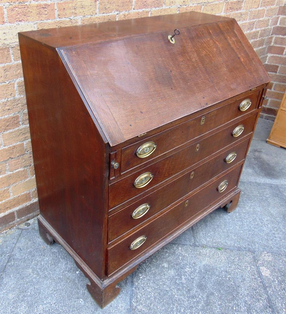 A GEORGE III OAK BUREAU  with fitted interior over four long drawers on bracket feet, 102cm wide