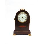 AN EDWARDIAN INLAID MAHOGANY MANTLE CLOCK  with lion mask brass handles to the sides, the enamel