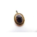AN AMETHYST AND SAPPHIRE 18 CARAT GOLD PENDANT the cabochon enclosed by sapphires and sapphires to