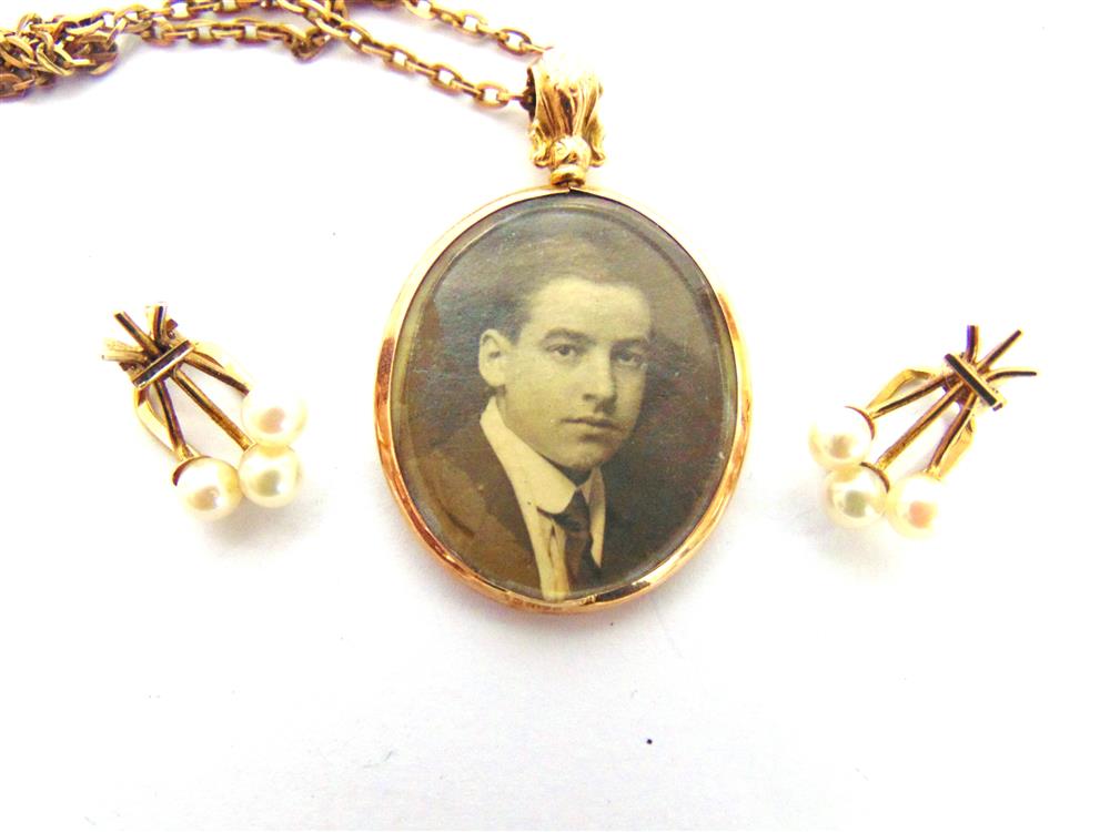 A 9 CARAT GOLD PICTURE PENDANT Birmingham 1915, of oval outline, on a chain; with a pair of 9