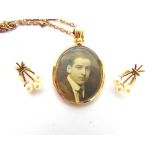 A 9 CARAT GOLD PICTURE PENDANT Birmingham 1915, of oval outline, on a chain; with a pair of 9