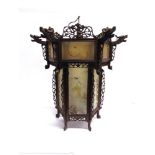 AN ORIENTAL HANGING LANTERN , of hexagonal form, the hardwood frame with open fretwork carving and