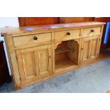 A LARGE STRIPPED PINE DRESSER BASE,  fitted with three drawers over cupboard and pot shelf, 213cm