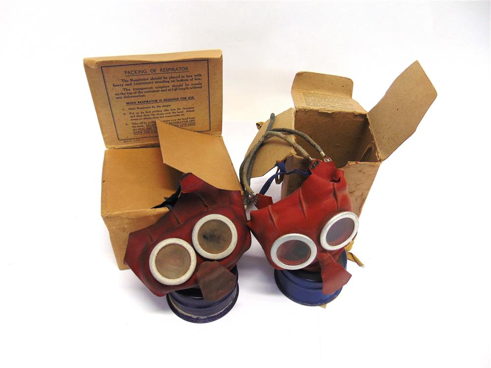 TWO SECOND WORLD WAR BRITISH 'MICKEY MOUSE' GAS MASKS each boxed (both with wear / tears to red