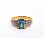 A BLUE ZIRCON RING stamped '18ct' and 'Plat', the oval cut stone, 8.5mm by 7.3mm by 4.6mm deep,